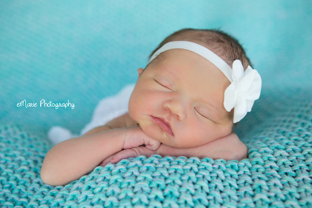 Newborn sleeping on teal blanket
