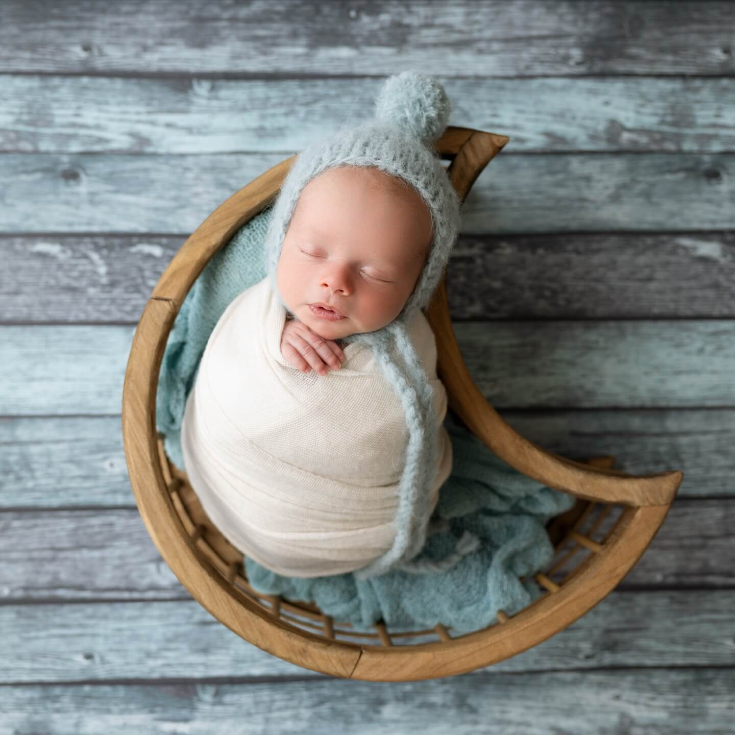 baby boy sleeps in moon shaped basket in newborn photography studio billings mt