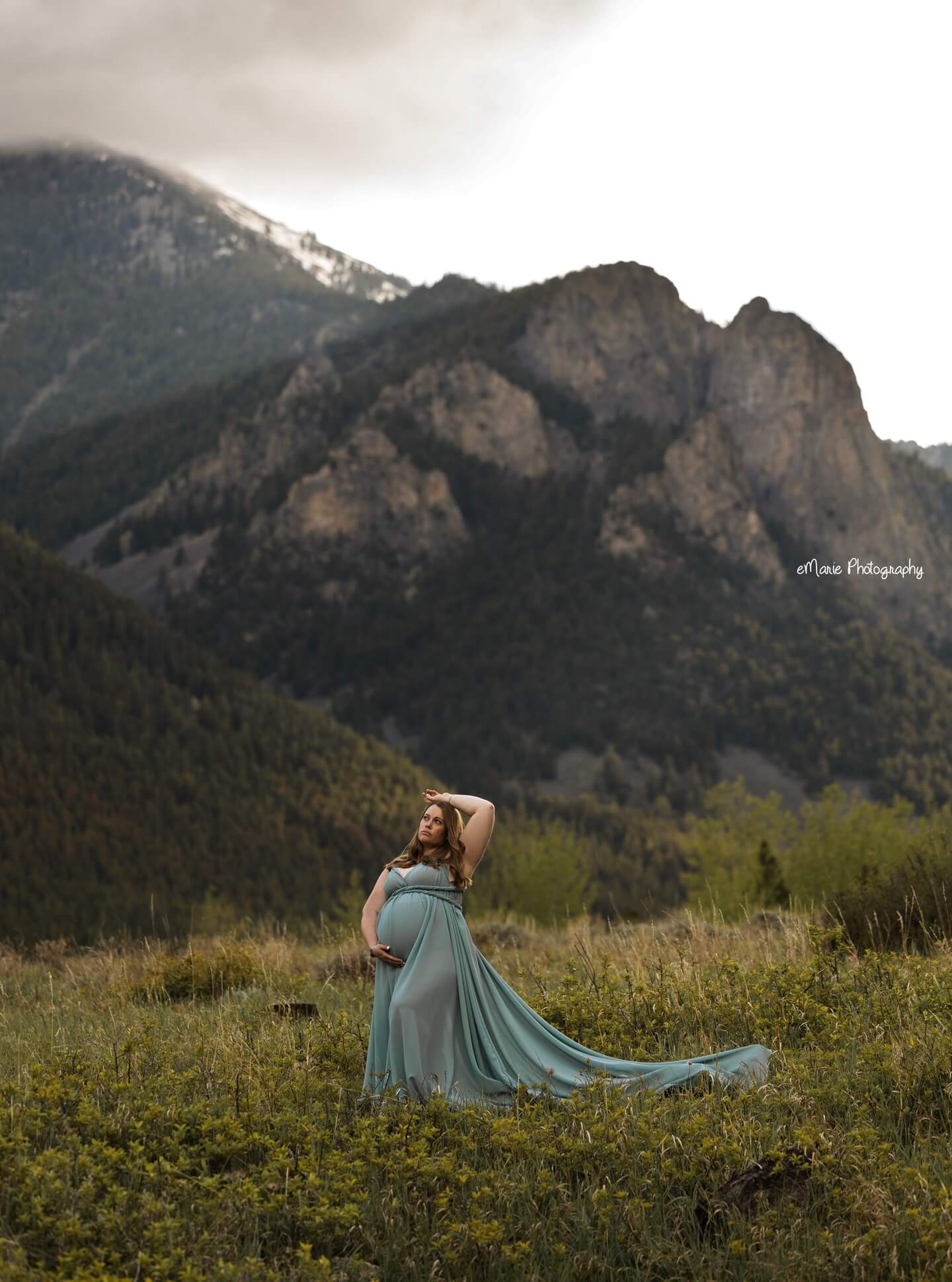 pregnant mamma stands in front of mountains in gorgeous maternity session