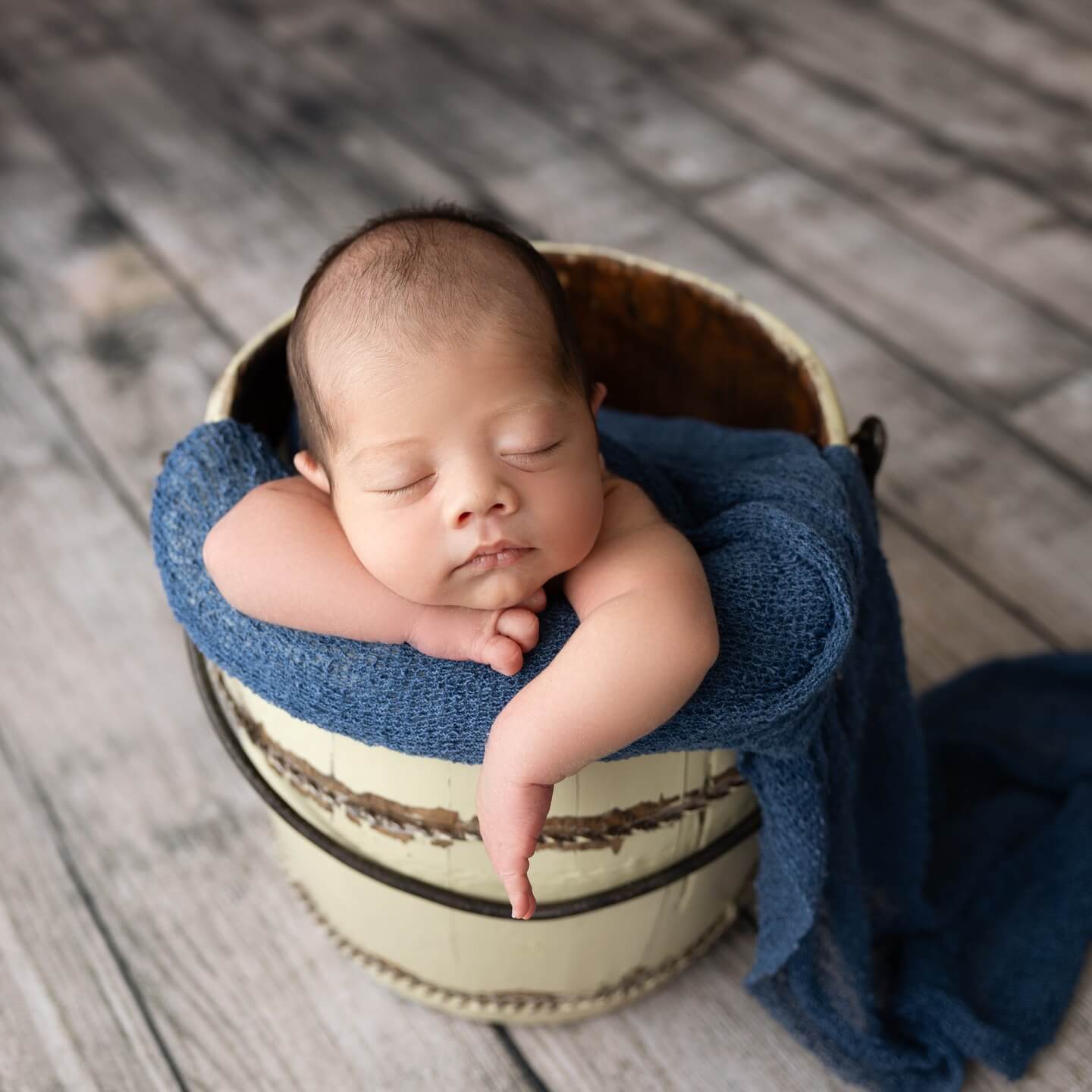 cute little baby boy sleeps in blue blanket and basket