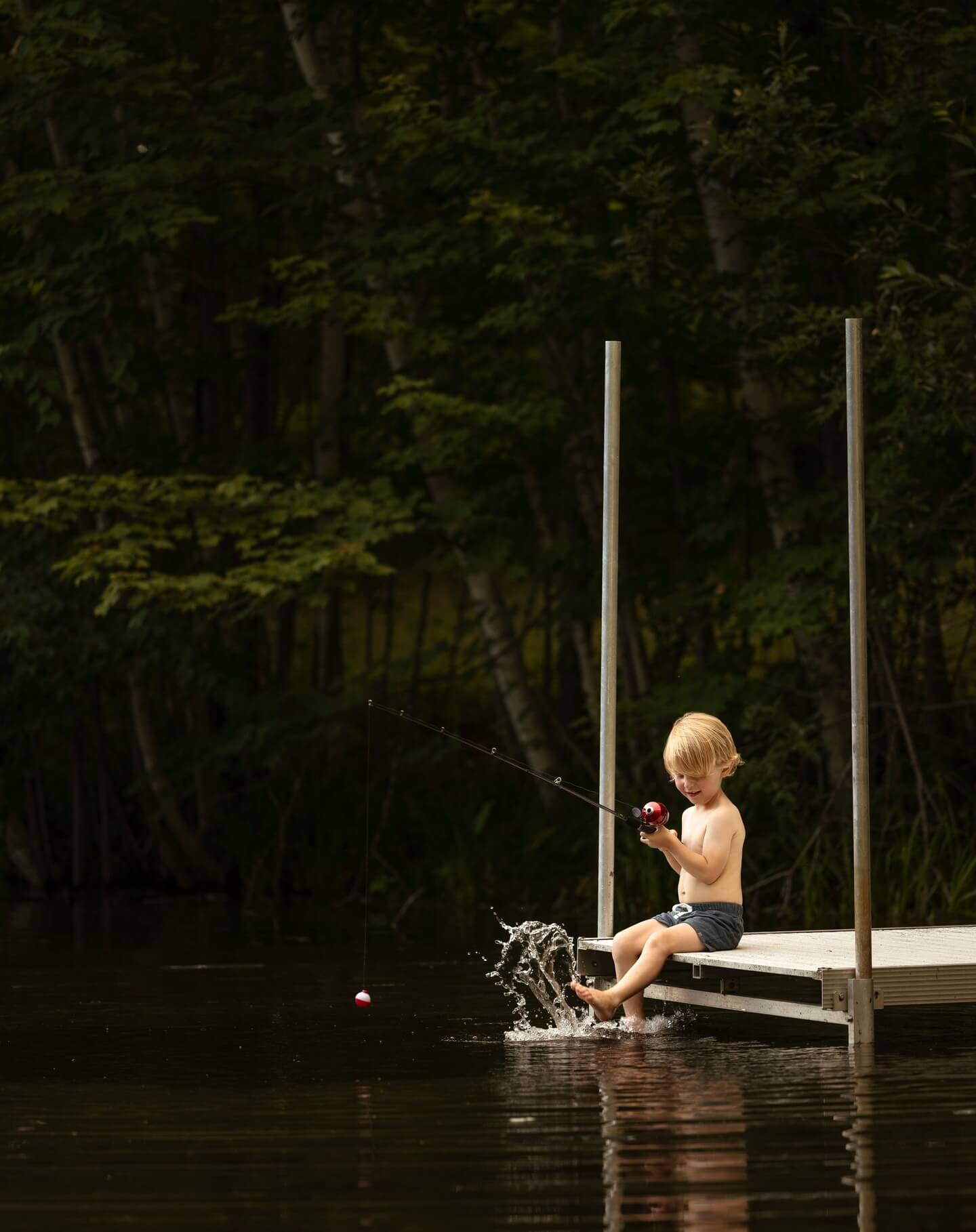 toddler fishes while dipping his toes in the water billings mt
