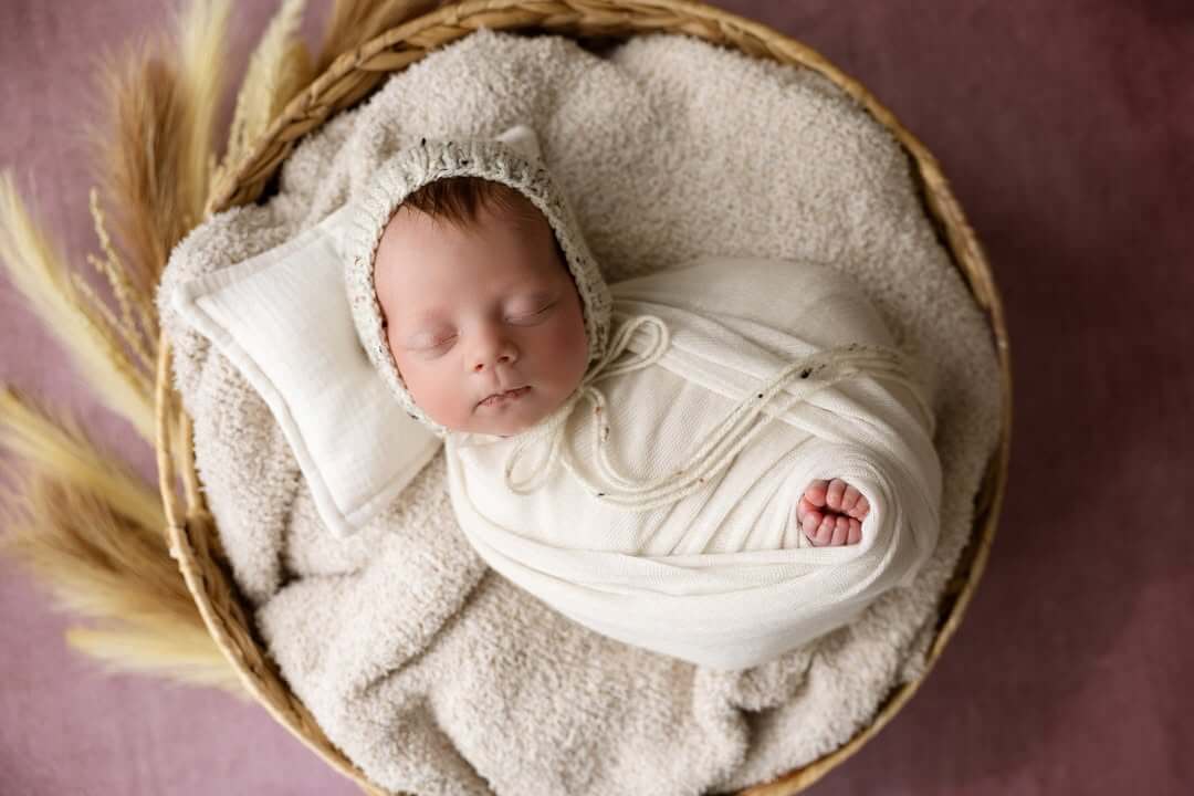 sweet baby girl sleeps in basket and blanket with wheat newborn photography in billings mt