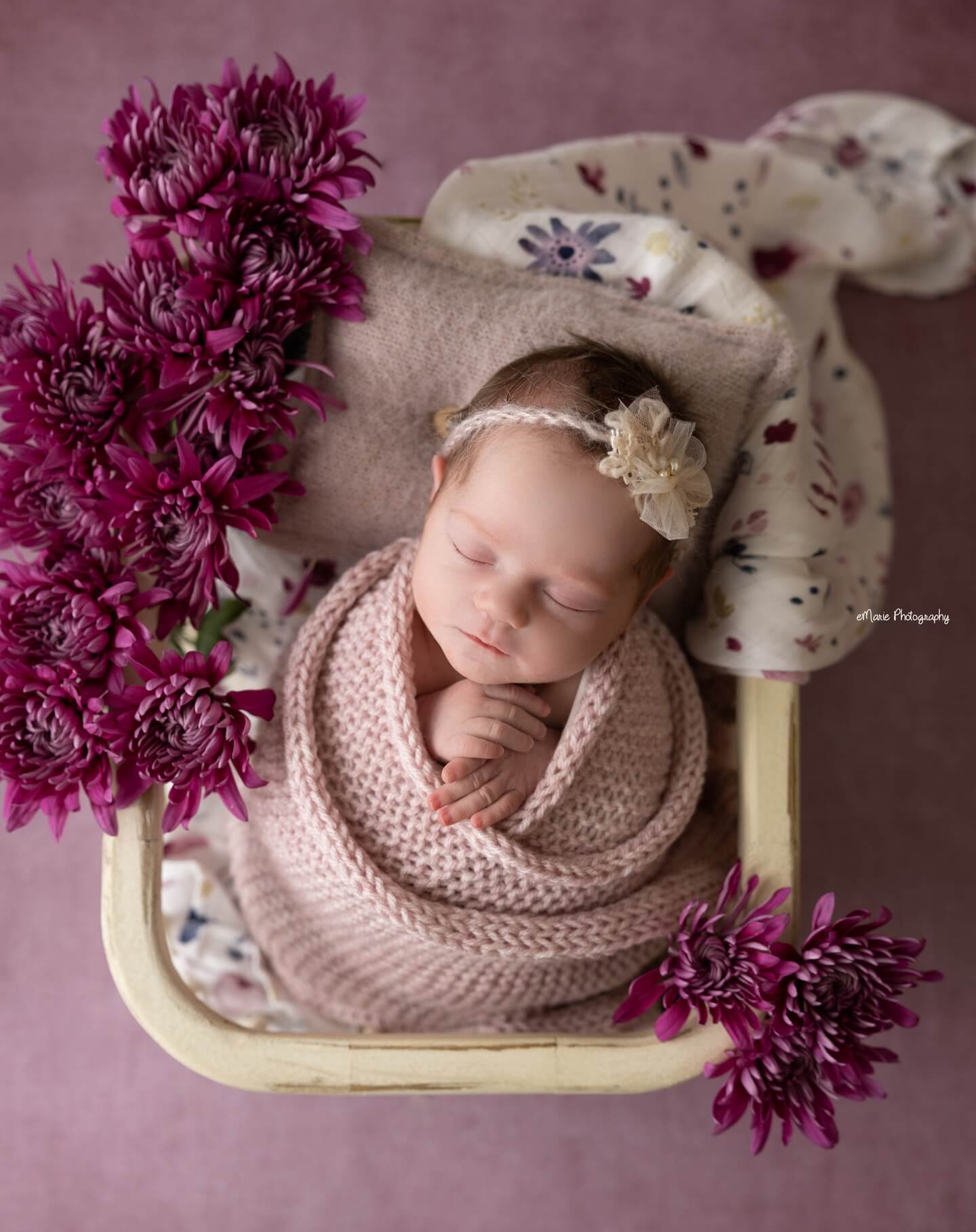 newborn girl sleeps in a pink blanket surrounded by pink flowers billings mt baby pictures