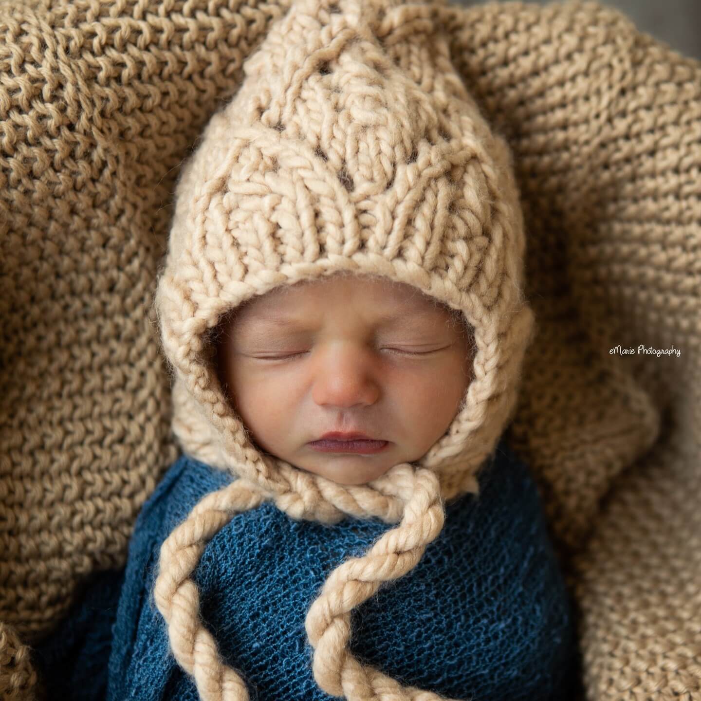 cute newborn boy sleeps in brown knit hat and brown knit blanket