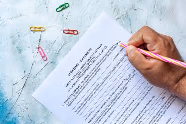 Hand signing a purchase agreement