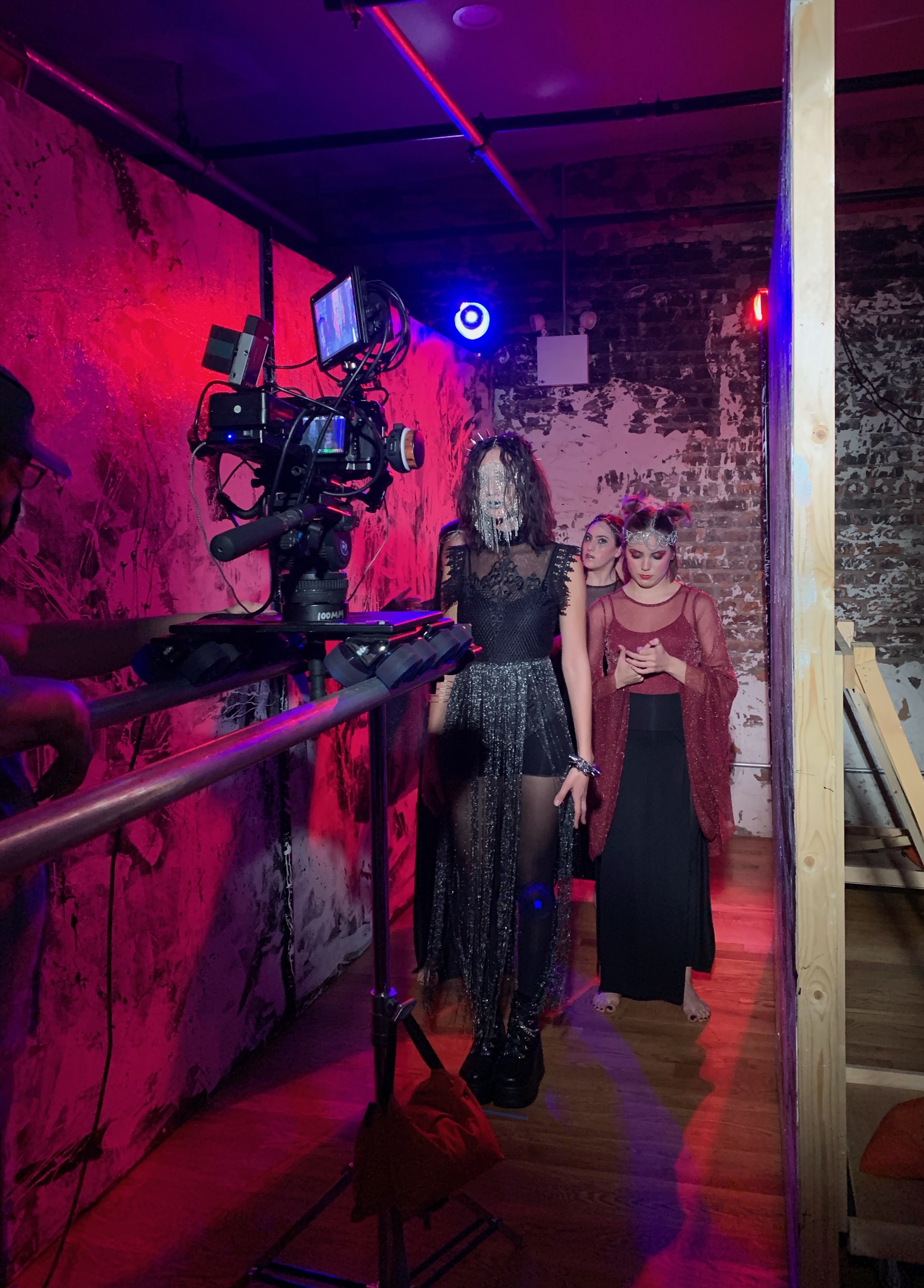 Camera on a dolly track filming performers on a music video set