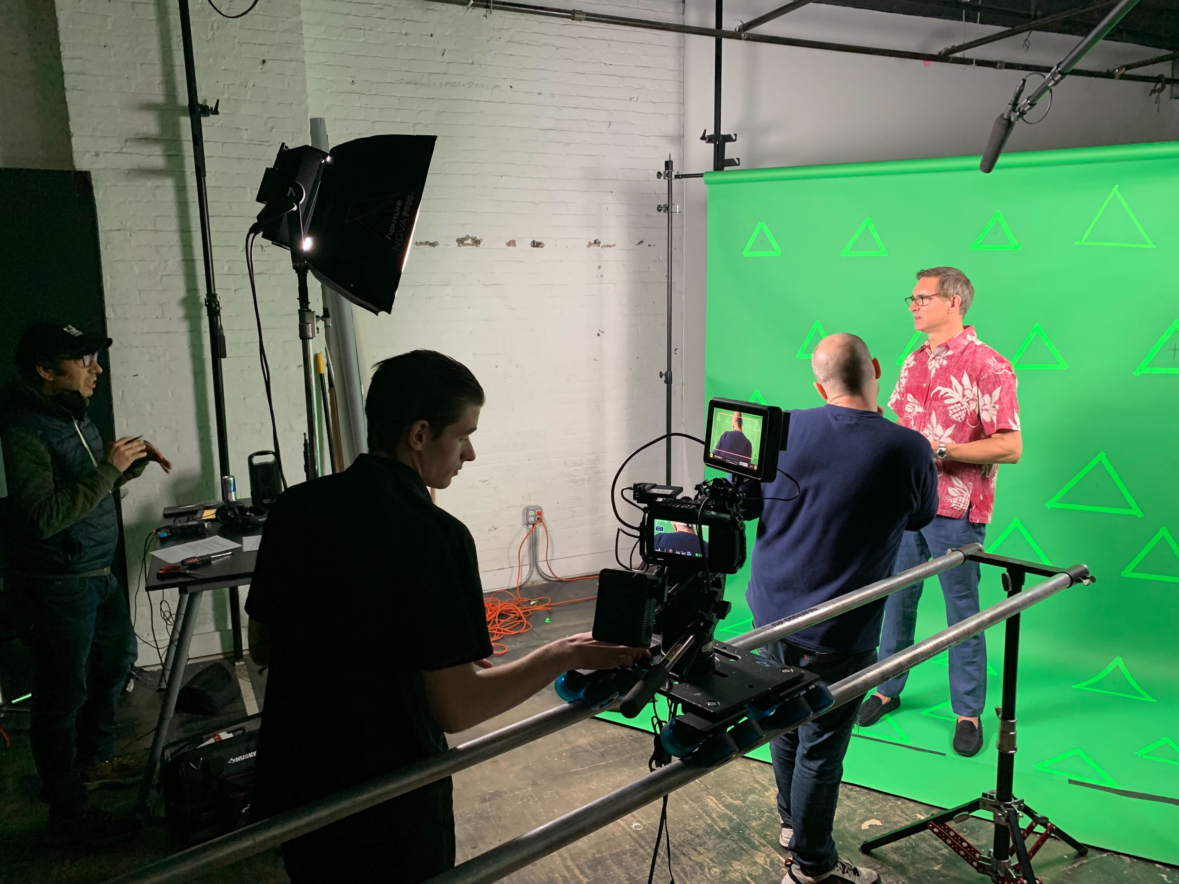 Crew filming an interview against a green screen