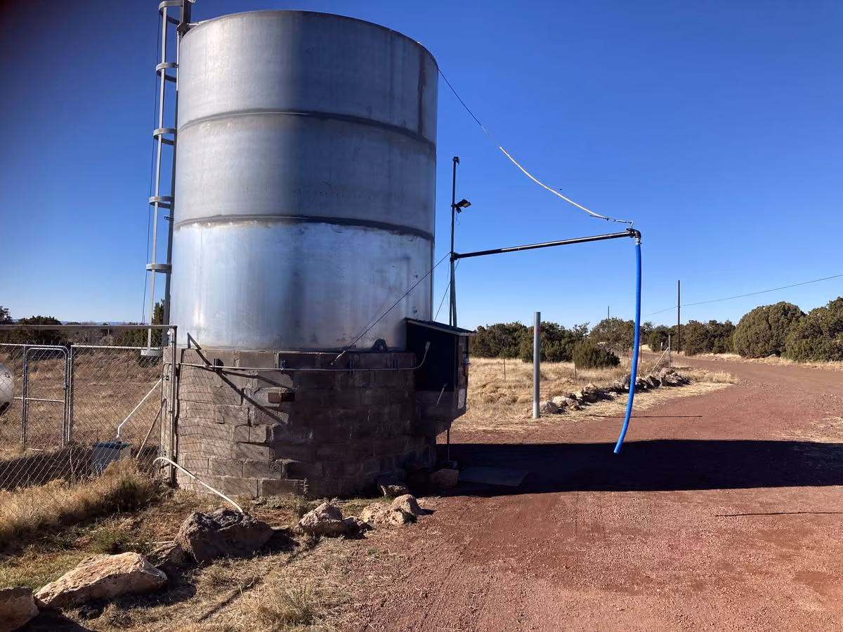 Small rural water storage tank with corrugated steel exterior serving a community water system