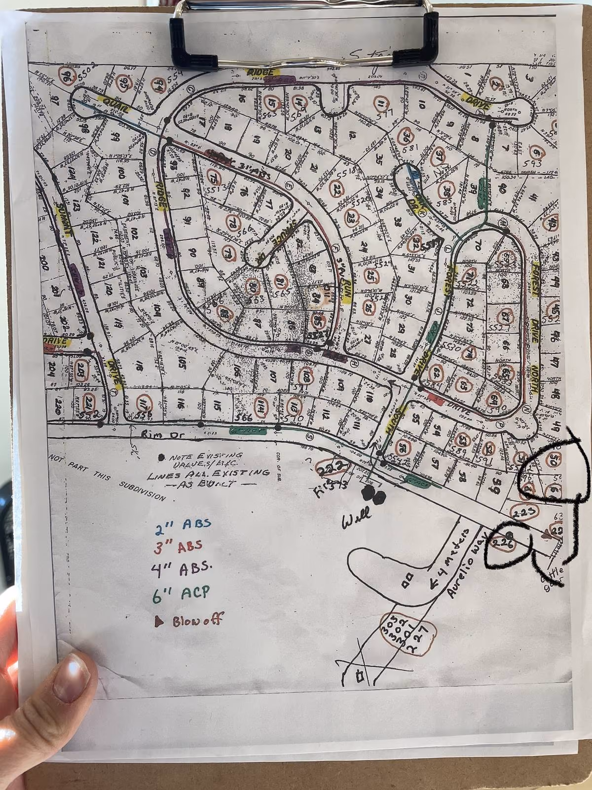 Paper clipboard with subdivision as-built map used for field reference at a water utility
