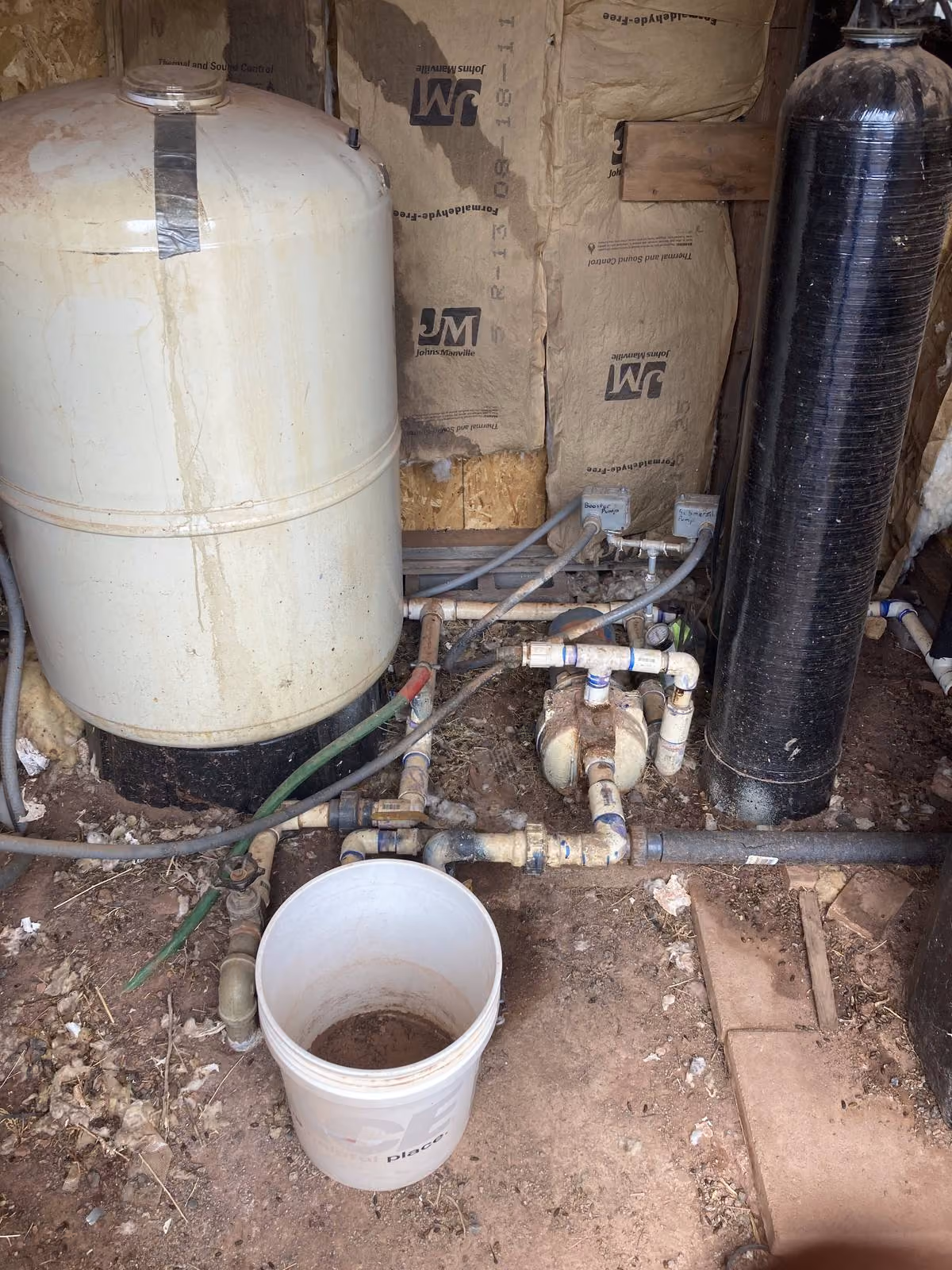 Pump house interior with pressure tanks and water treatment system — the infrastructure utilities track costs on