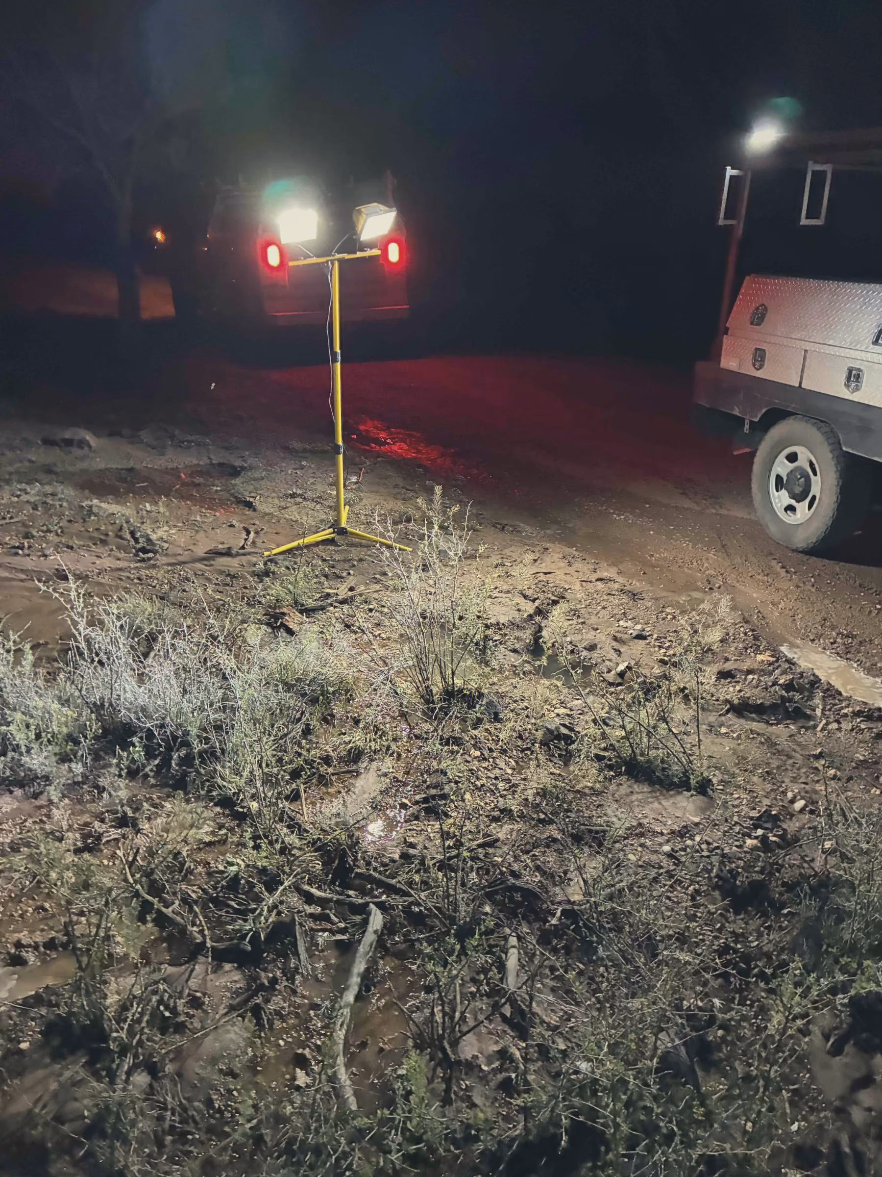 Utility crew truck under floodlights on a rural night job