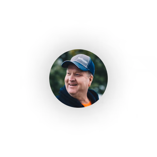 Wastewater Utility Operator who is a middle-aged man wearing a blue and gray cap and a navy hoodie with a blurred outdoor background. Uses Ziptility for Work Management
