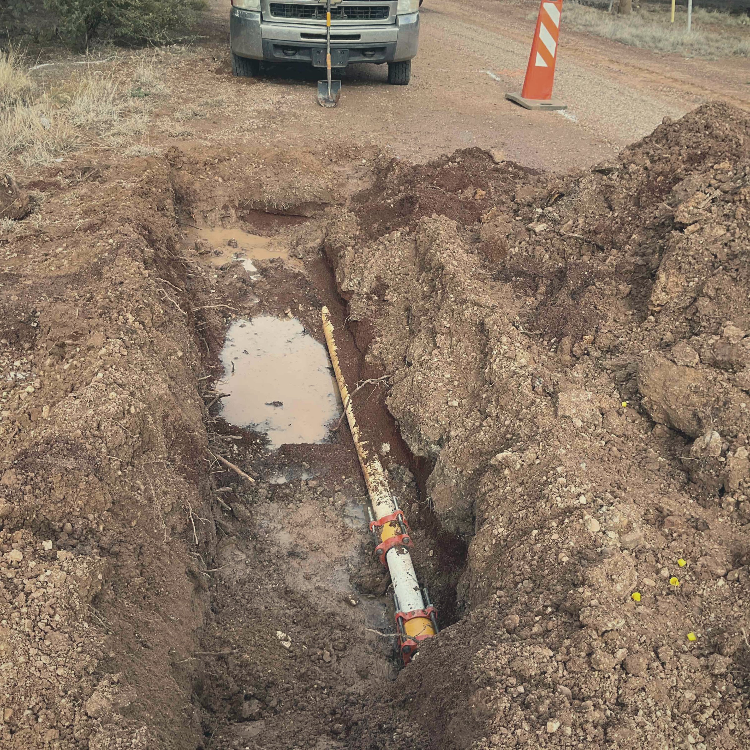 Open water main trench beside the road