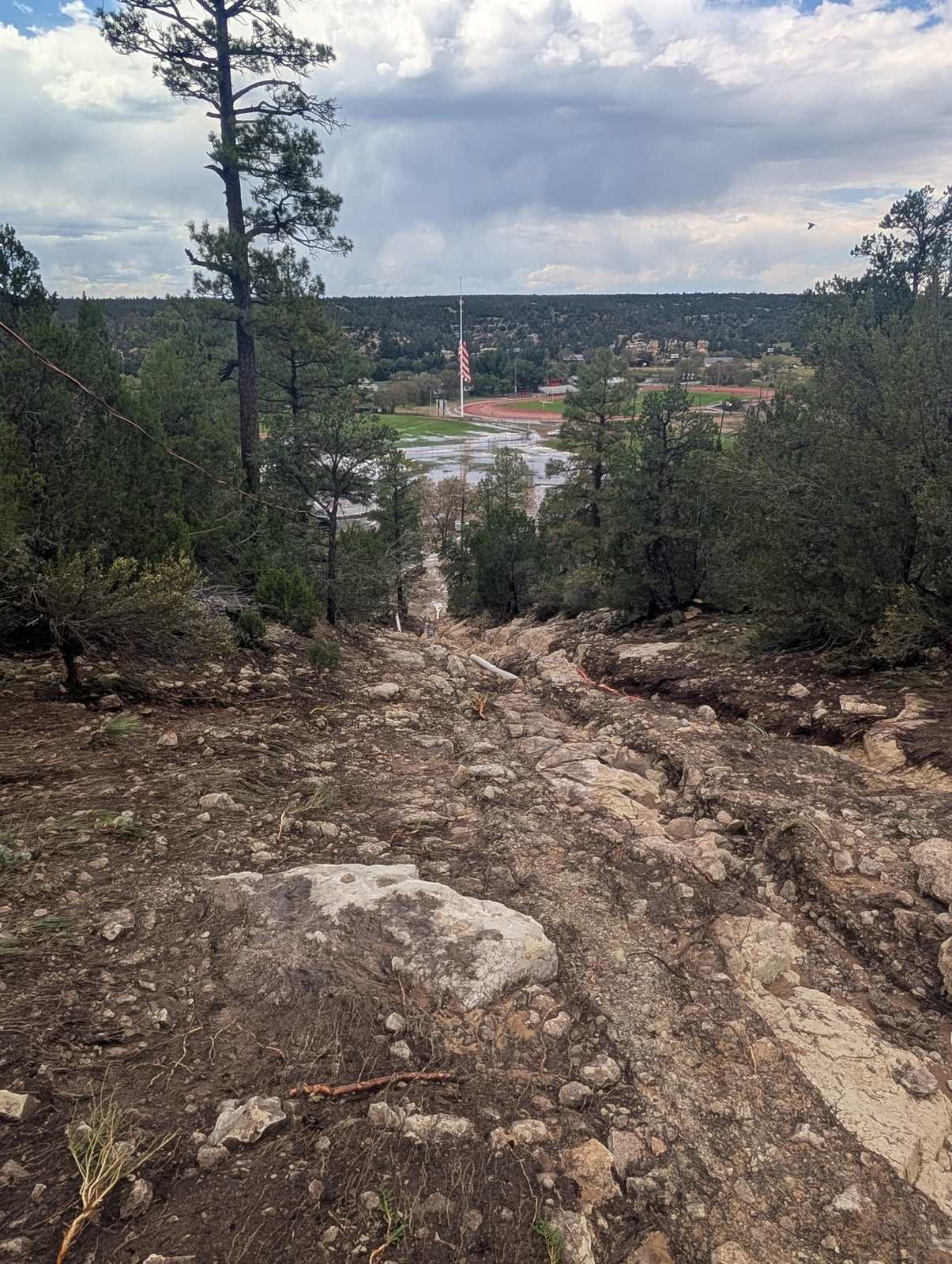 The scour channel cut by the released water, running downhill from the Heber DWID tank site toward the school athletic fields.