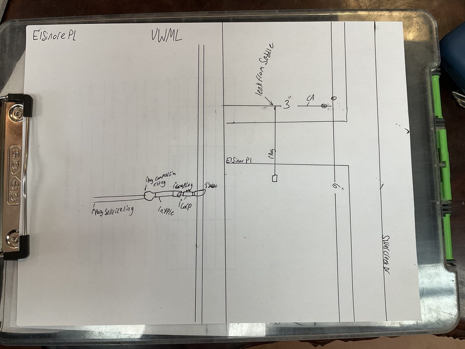 A water system schematic, hand-kept on a clipboard: a service line and a leak, sketched by hand.