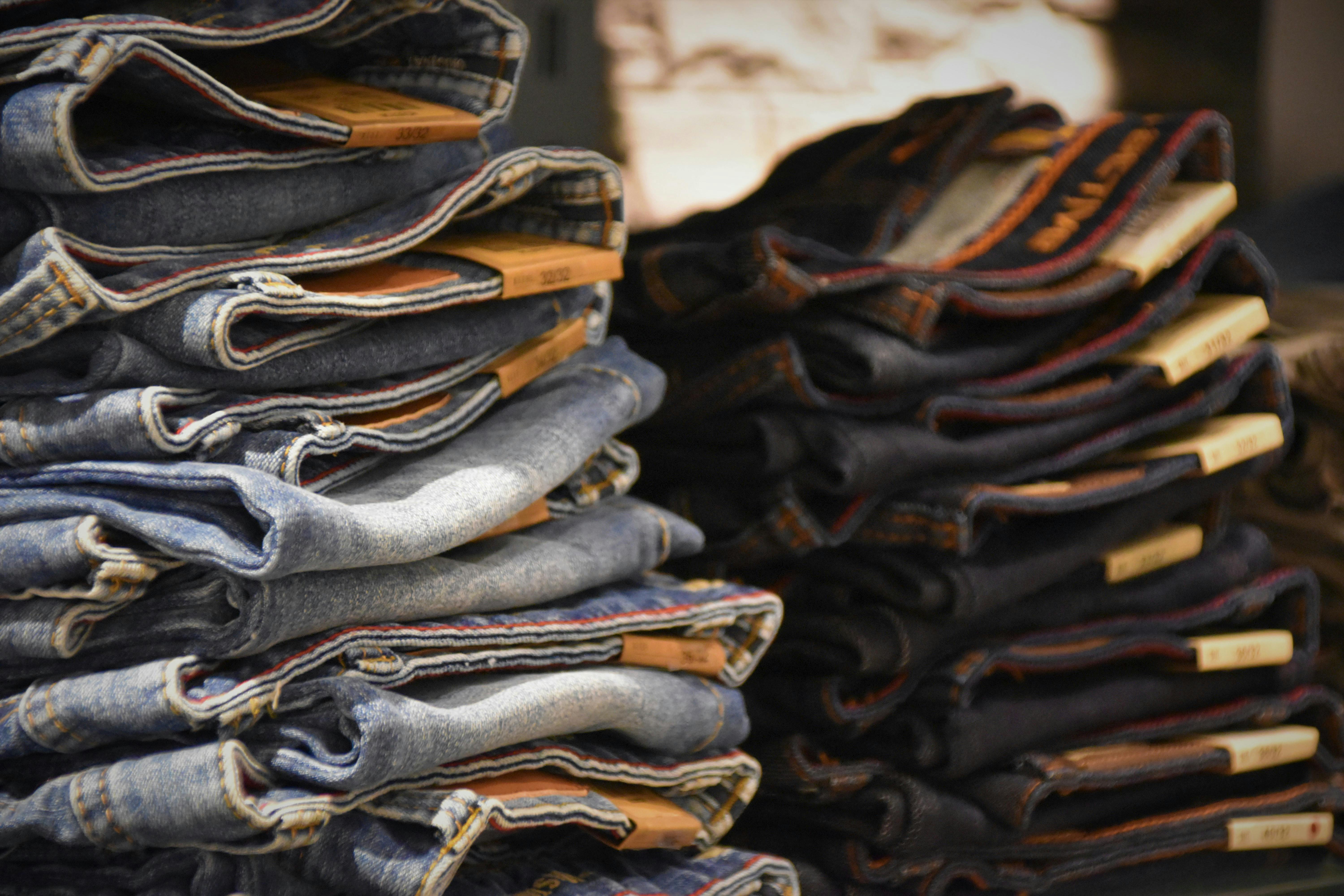 a stack of jeans on a shelf