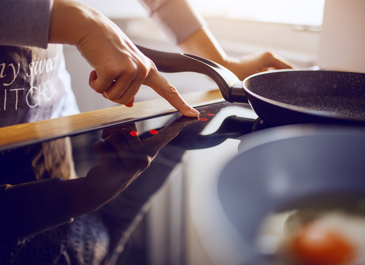 a person touching a touch screen on a stove