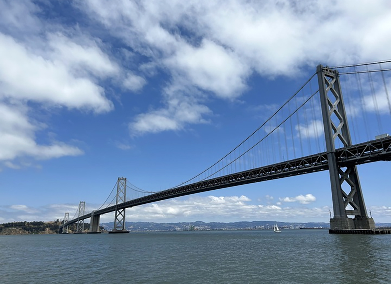 a bridge over water with a sailboat