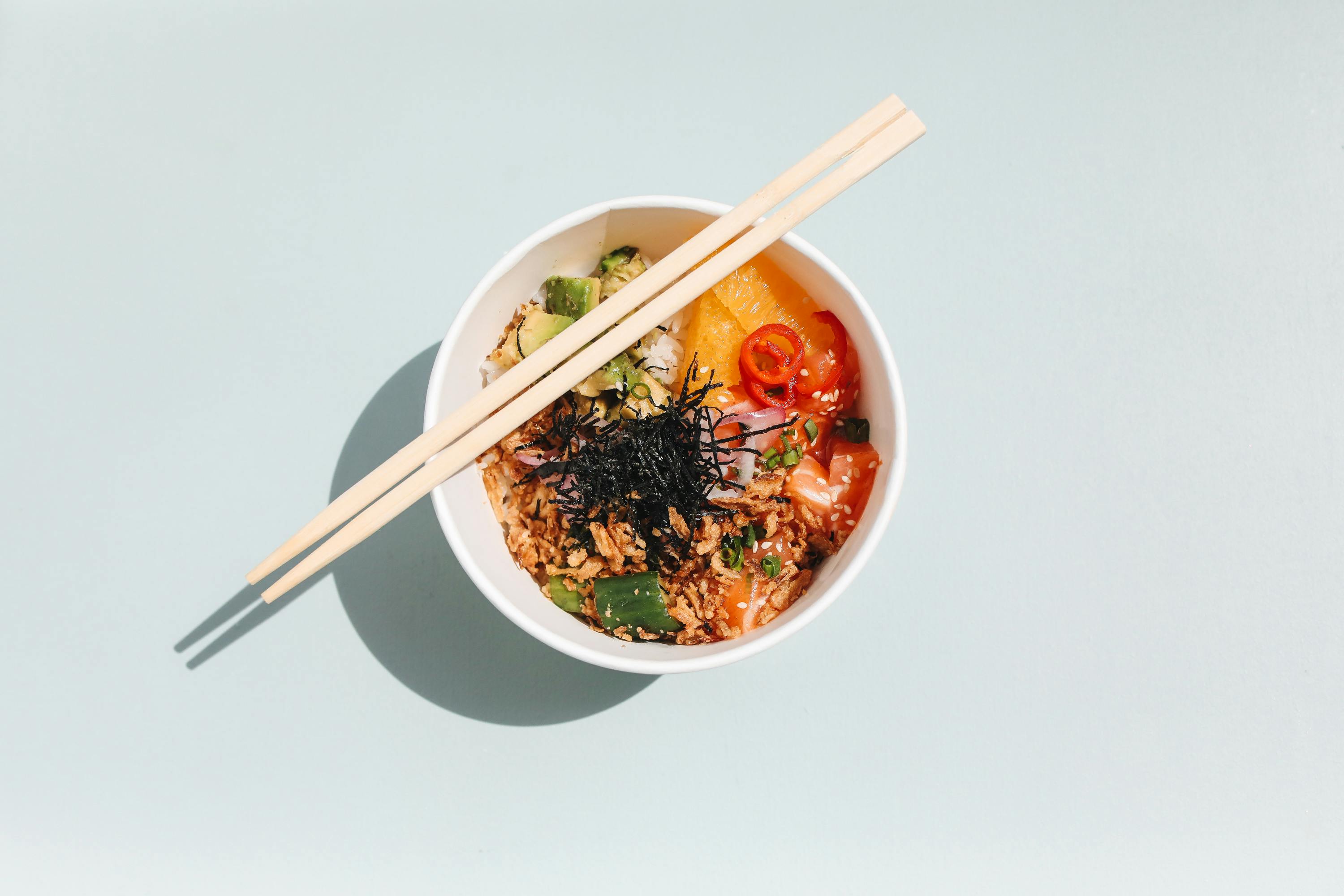 a bowl of food with chopsticks