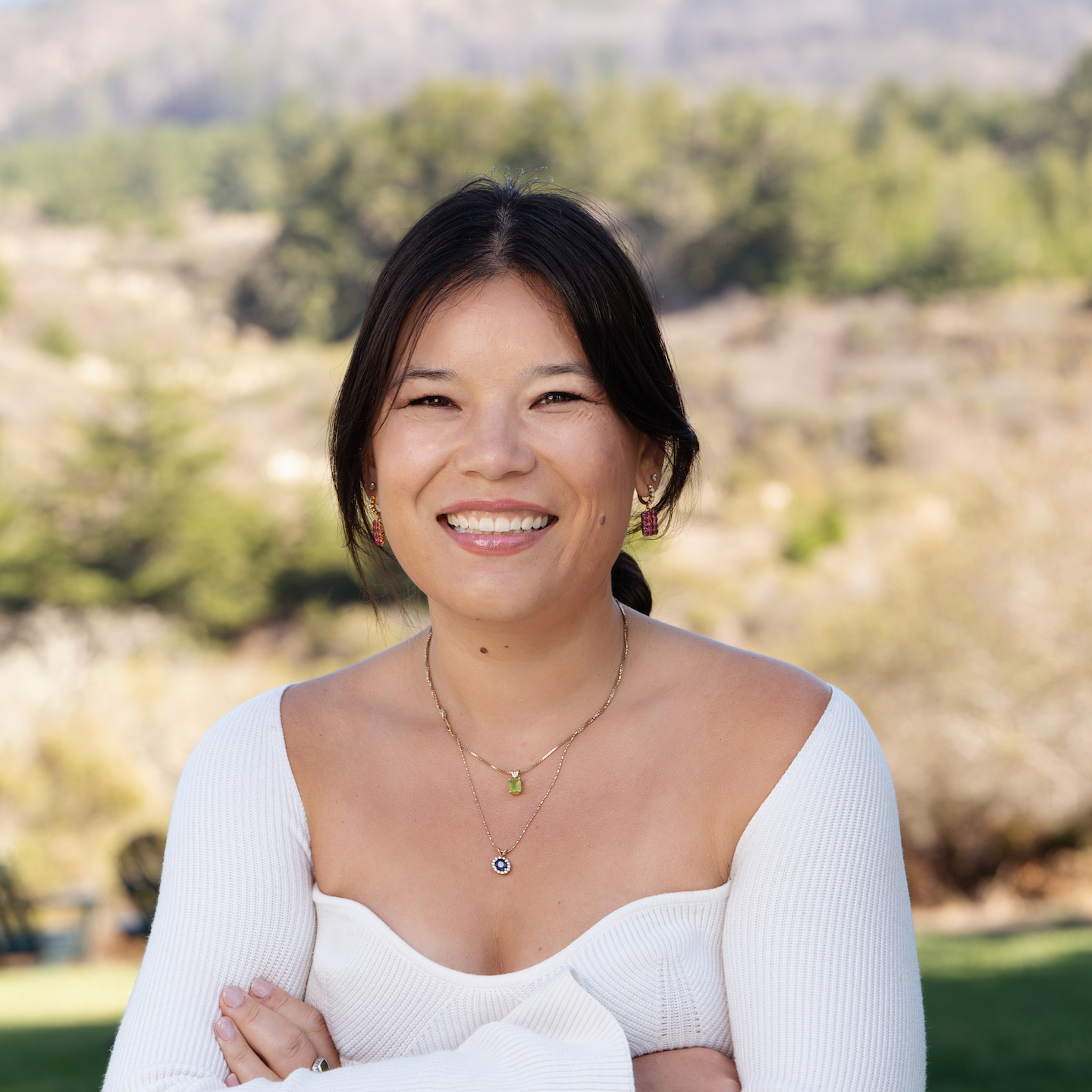 a woman smiling with arms crossed
