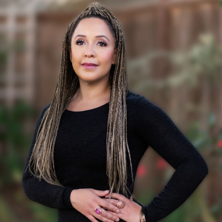 a woman with long braids posing for a picture