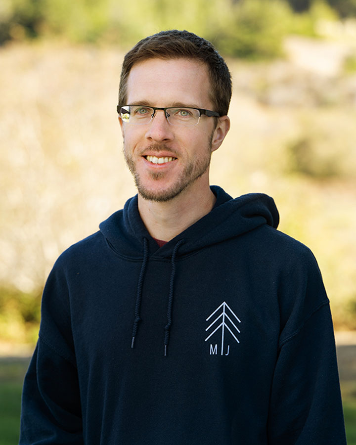 a man wearing glasses and a black sweatshirt