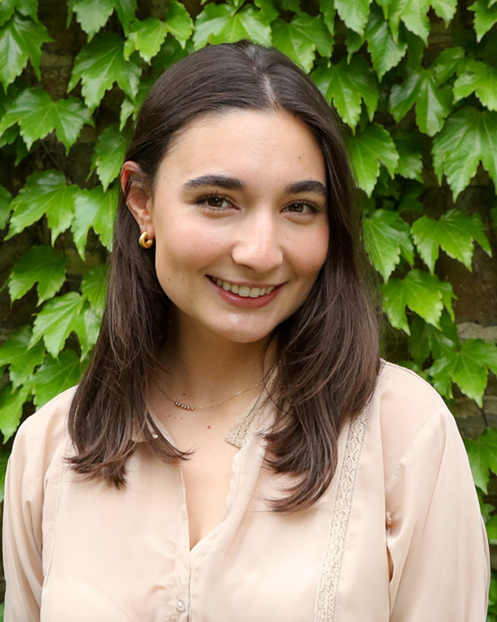 a woman smiling in front of a green wall
