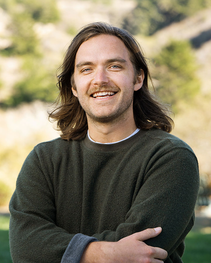 a man with long hair smiling