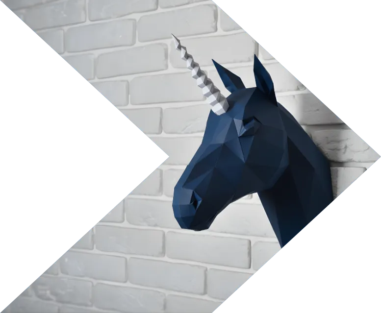 Geometric dark blue unicorn head sculpture mounted on a white brick wall.