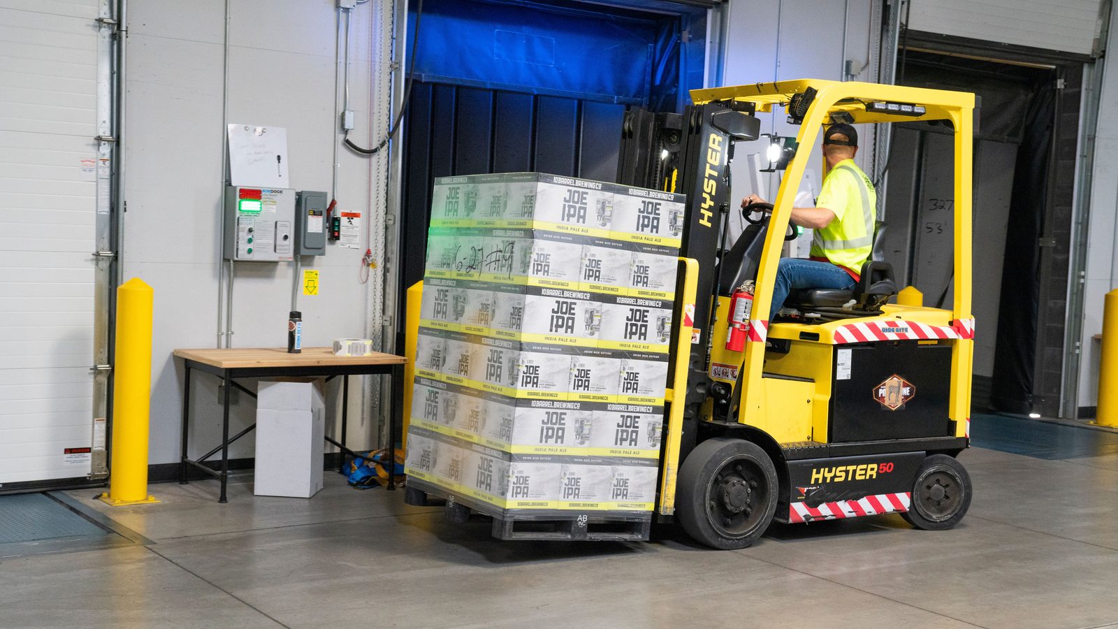 Forklift moving a wrapped pallet of goods inside a distribution centre