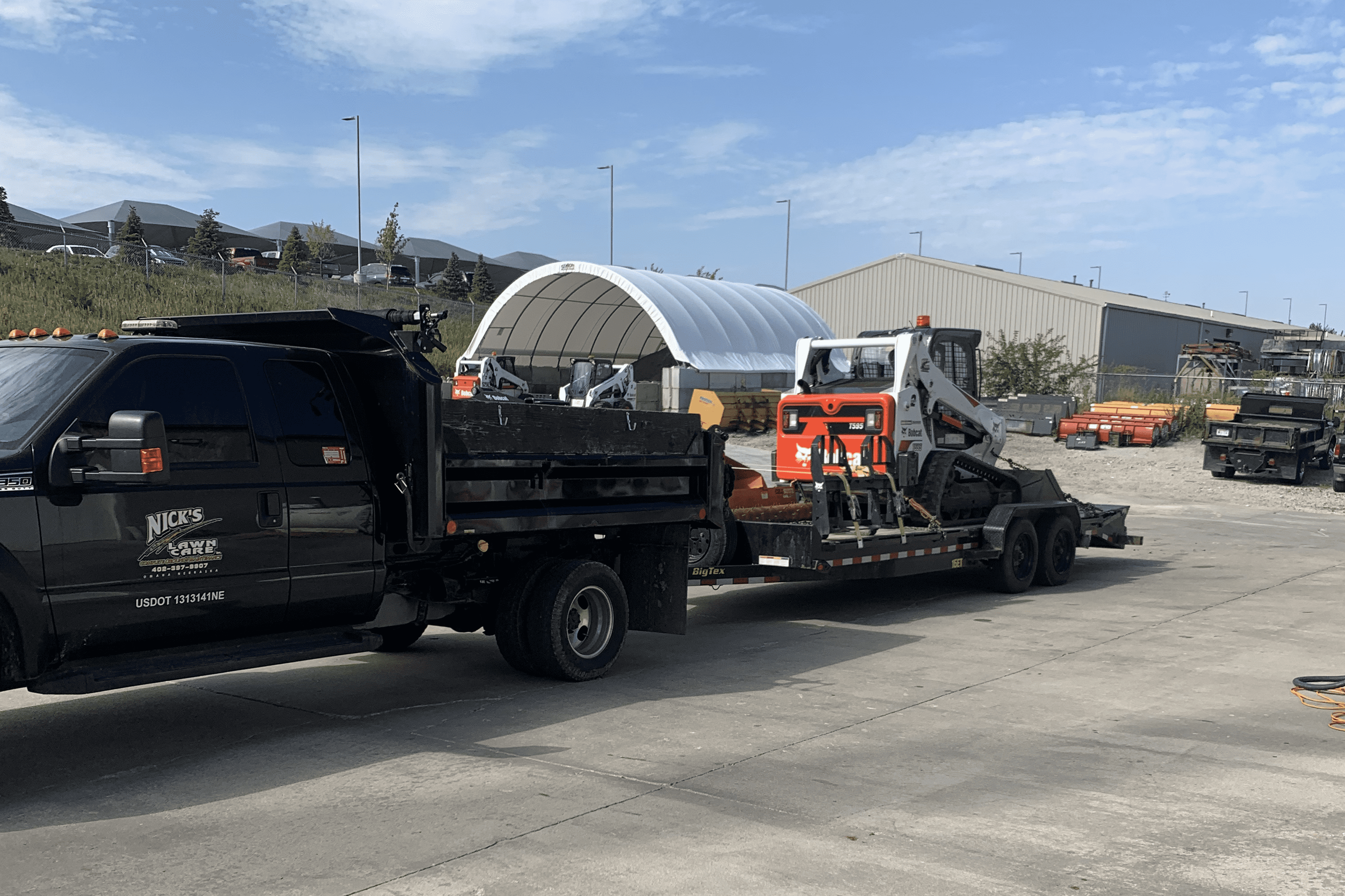 Nick's Lawn Care skid loader clearing a large property