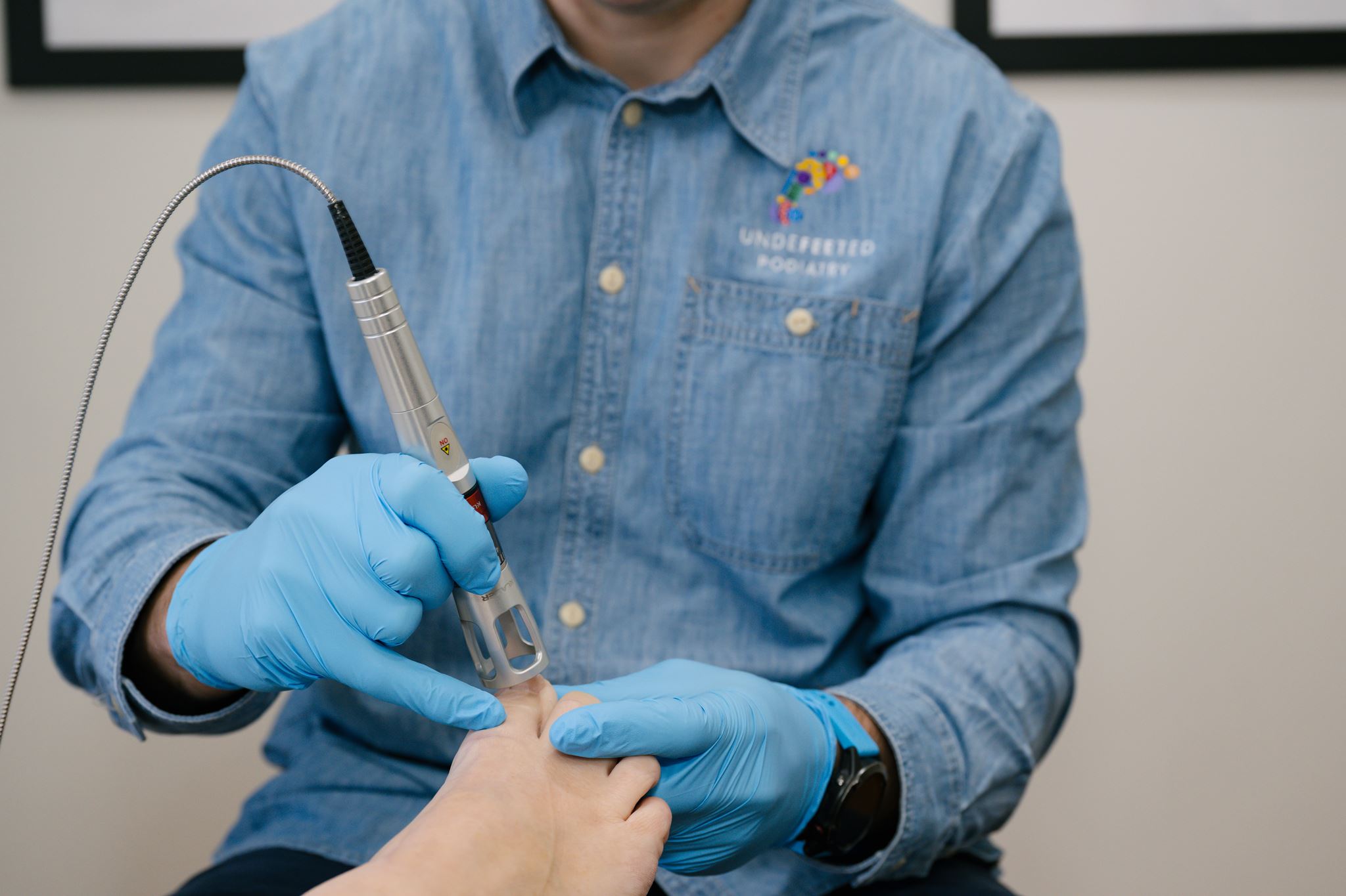 Podiatrist administering K-Laser treatment