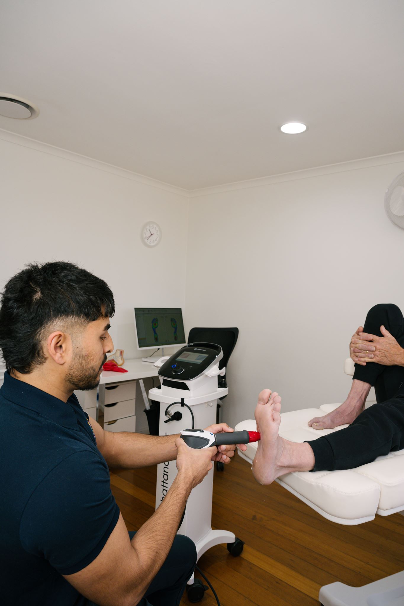 Podiatrist administering shockwave treatment