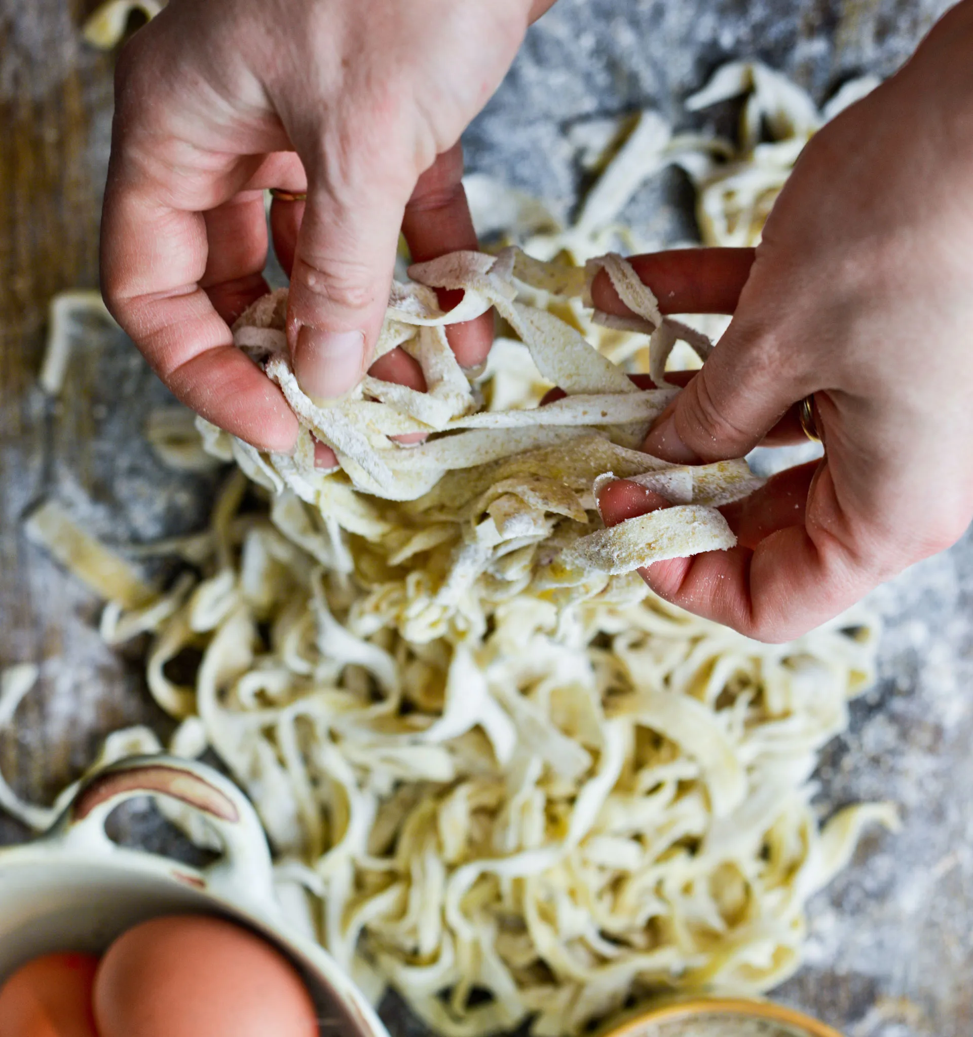 woman pulling apart fresh noodles during cooking class
