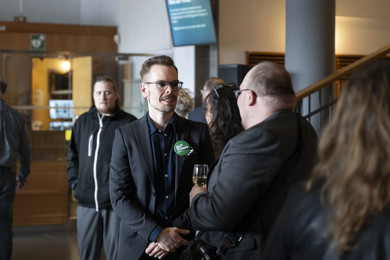 Andreas Varro talar med en utställningsbesökare.