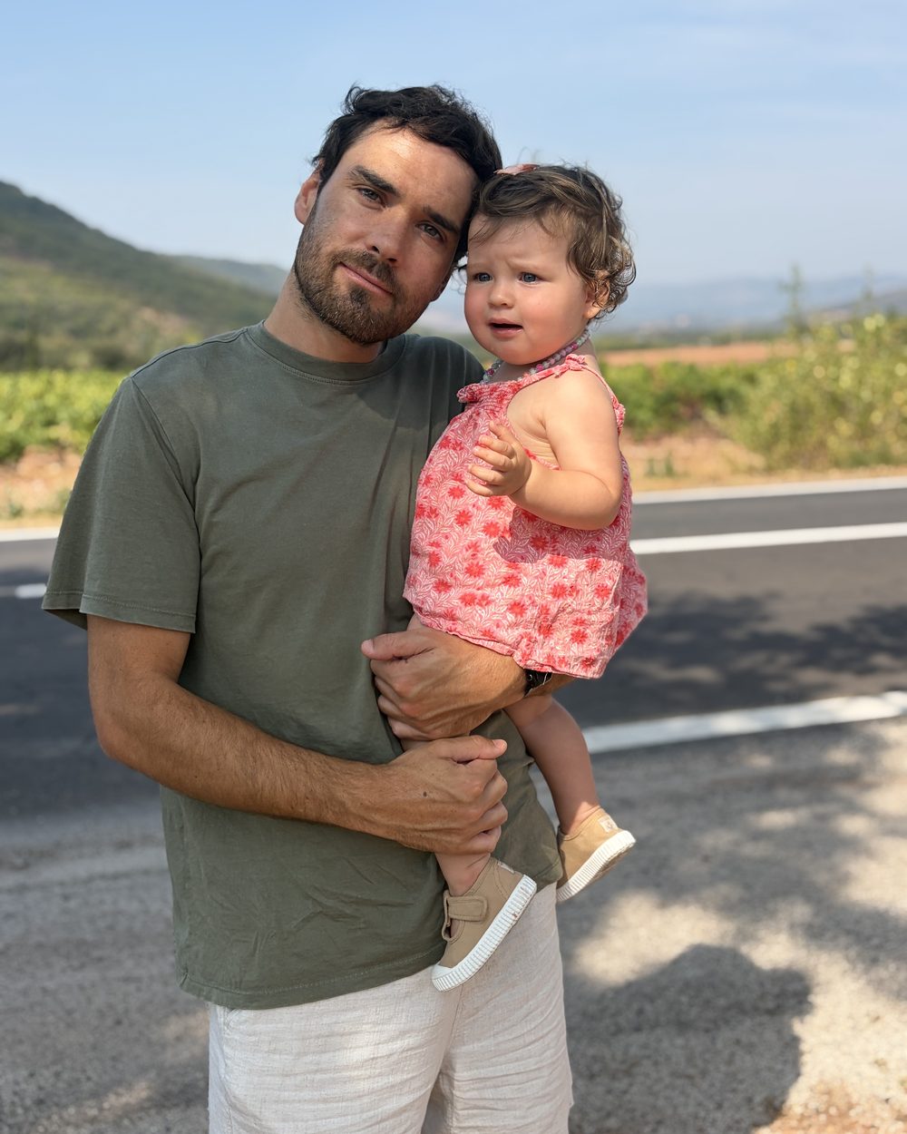Vincent Albouy holding his daughter on a country road in summer