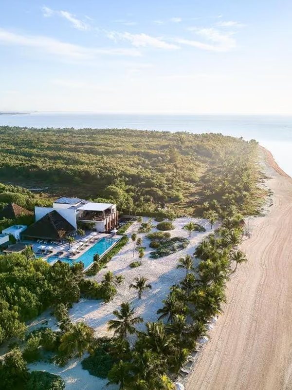 Aerial view of a beach resort with pools and palm trees
