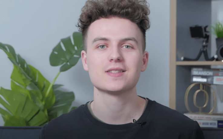 Man looking into camera with plant in background