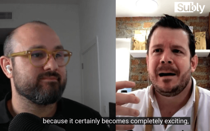 two men talking side by side on zoom call with subtitles on screen