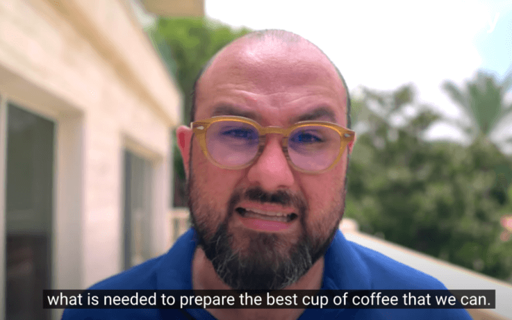 man speaking to camera outside in sunshine with subtitles on screen