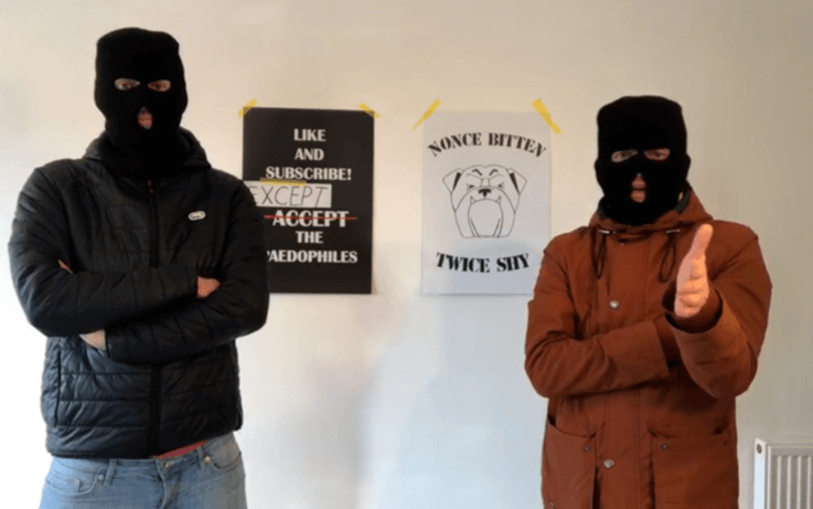 Two men in masks, arms crossed