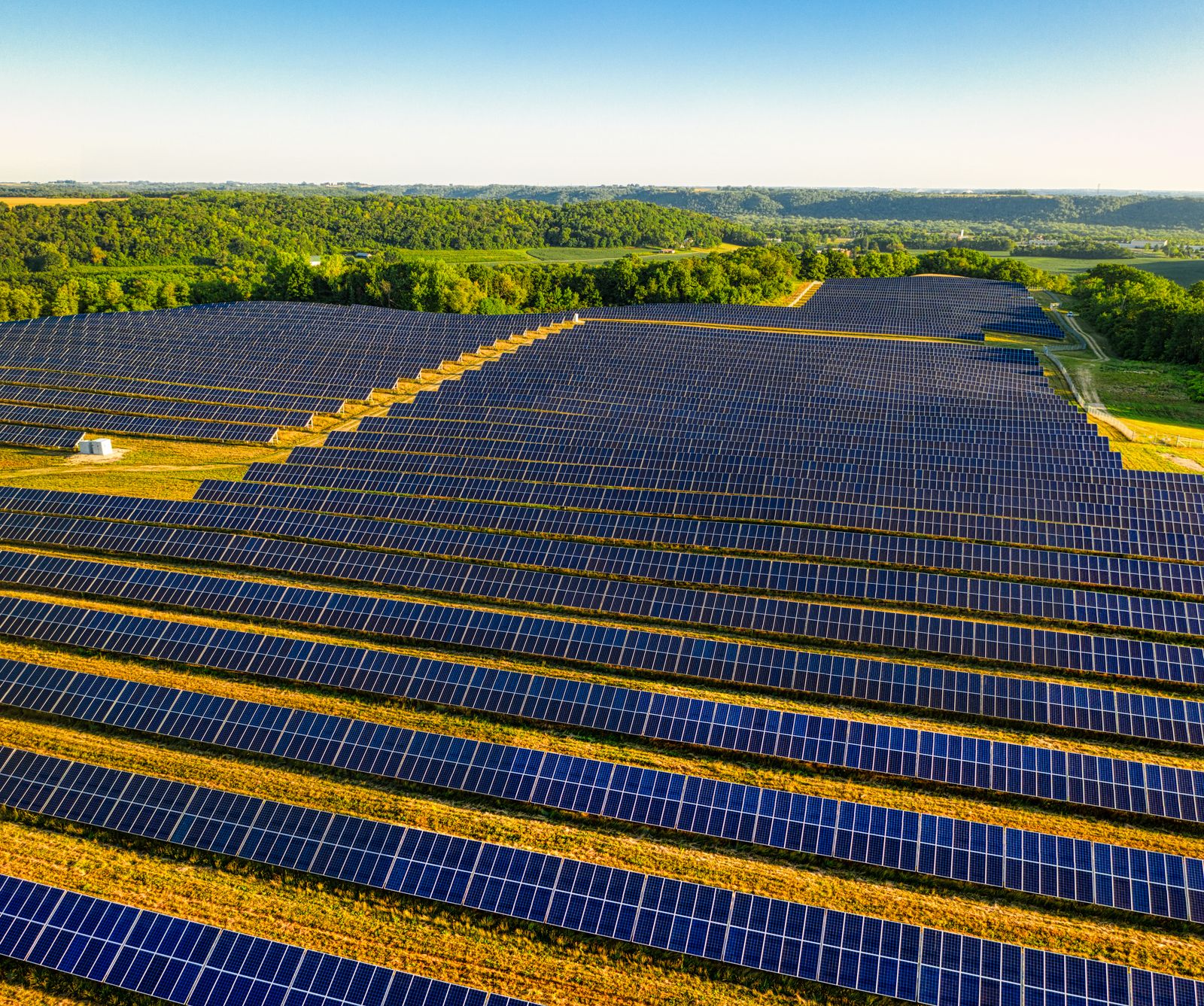 Symbolbild: Freiflächen-Solarpark in hügeliger, grüner Landschaft.