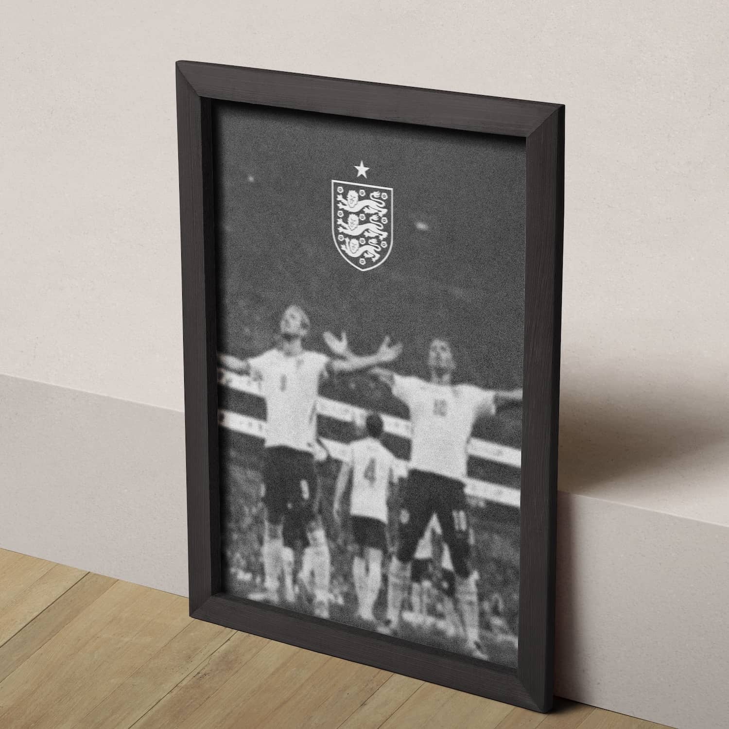 Black-and-white poster showing England football players celebrating beneath the England crest with a star above.