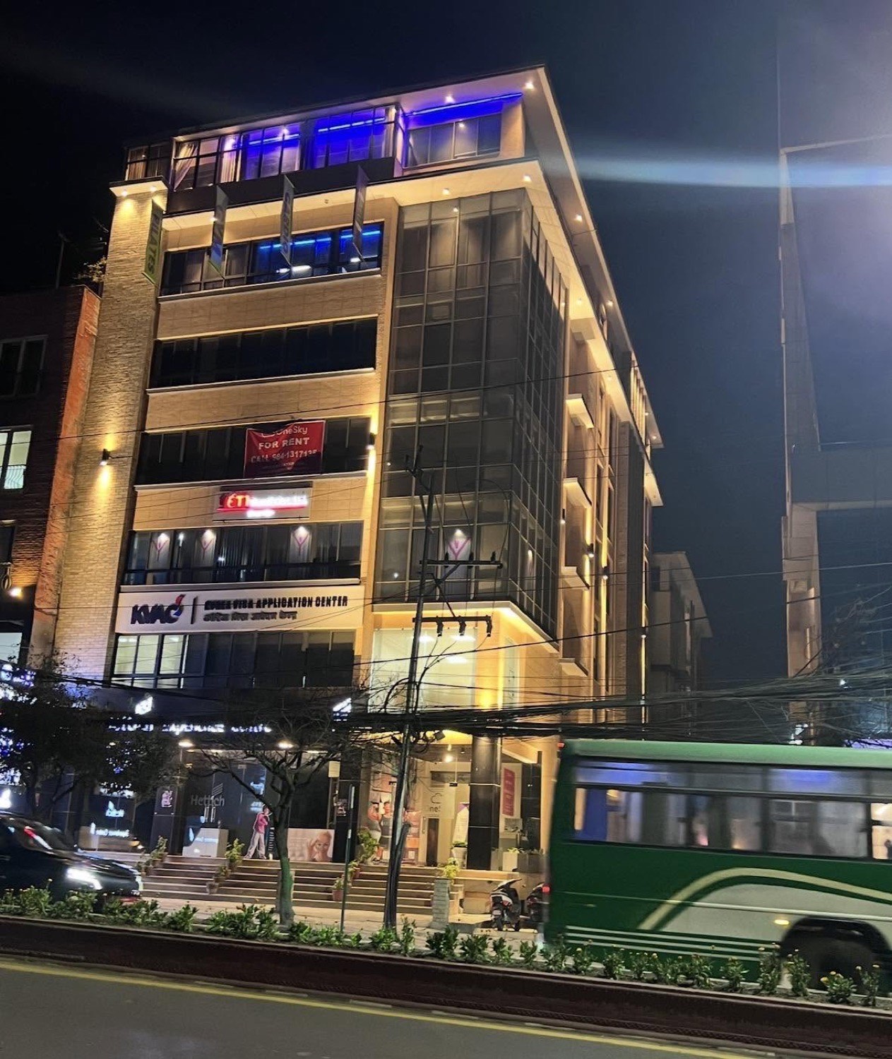 OneSky lit at night on Pulchowk main road, with the Korea Visa Application Center and Hettich signage visible