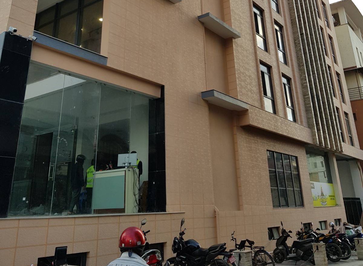 The side elevation of OneSky with motorbike parking along the access lane and the security post