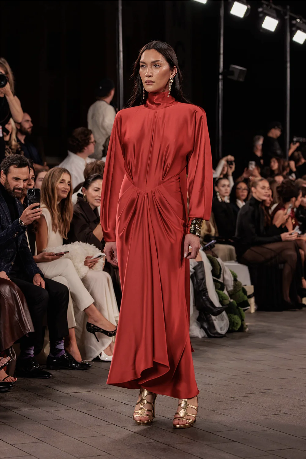 Model stuns in a red satin high-neck gown with ruched waist detailing at Carla Zampatti’s 60th Anniversary Runway Show during Australian Fashion Week 2025.