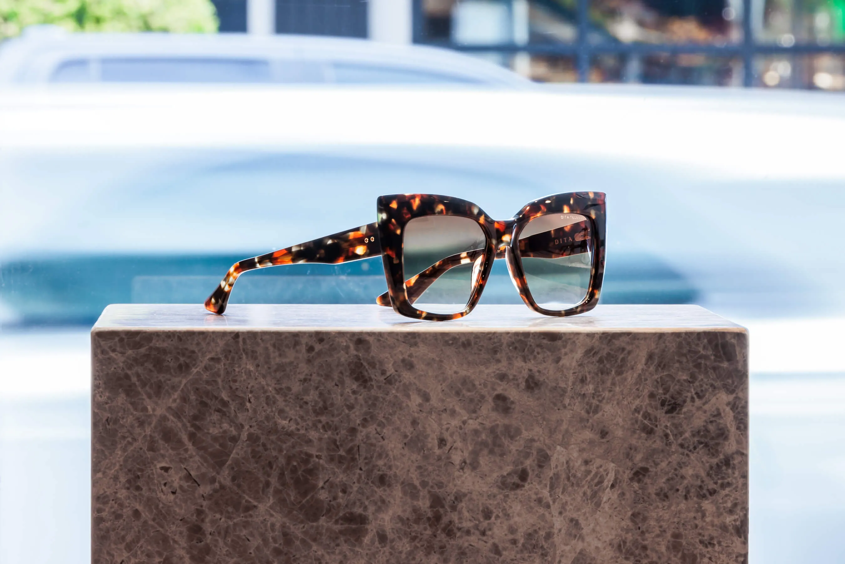 Elegant and bold, these tortoiseshell acetate sunglasses feature oversized frames and green-tinted lenses. Captured in natural light at Essu Designer Eyewear, Mosman | EDG Studios