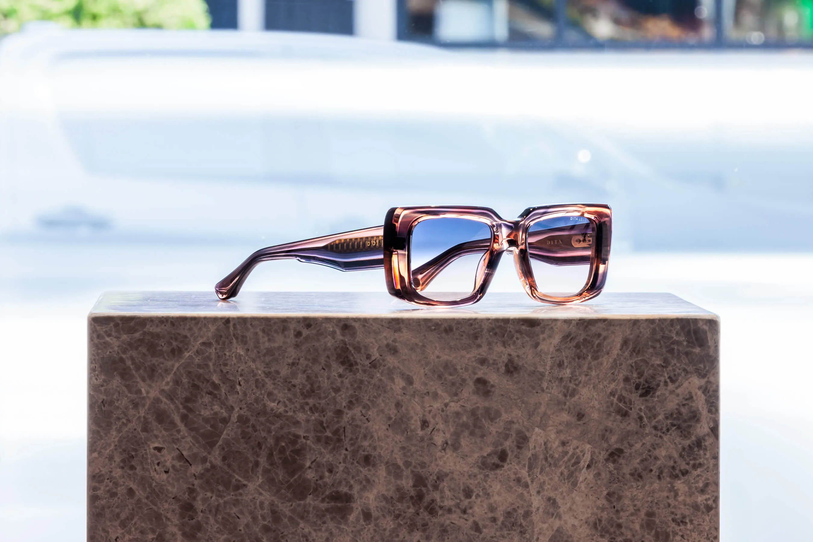 Featuring a statement silhouette and tinted translucent acetate, this pair of Dita eyeglasses rests on a dark stone pedestal. Captured at the Essu Designer Eyewear showroom in Mosman, Sydney | EDG Studios