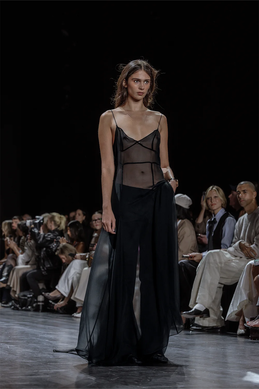 Model walks the Beare Park runway in a sheer black slip dress with flowing layers, embodying minimalist sensuality at AFW 2025.