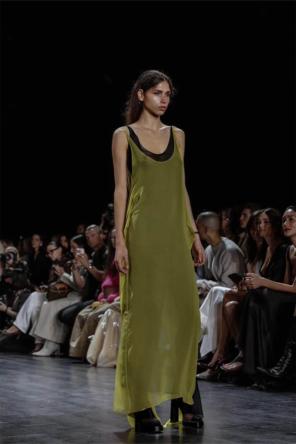 Model showcases a semi-sheer olive green maxi dress layered over a black underdress at Beare Park’s Australian Fashion Week 2025 runway show.